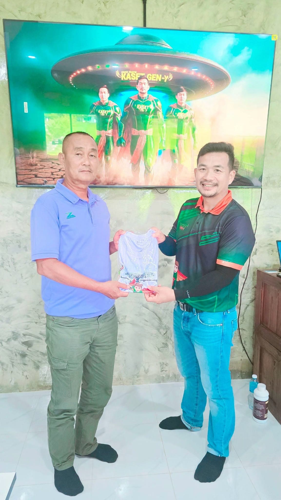 ผู้เข้าอบรมเสื้อโปโลสีม่วงรับถุงของที่ระลึกจากครูฝึก