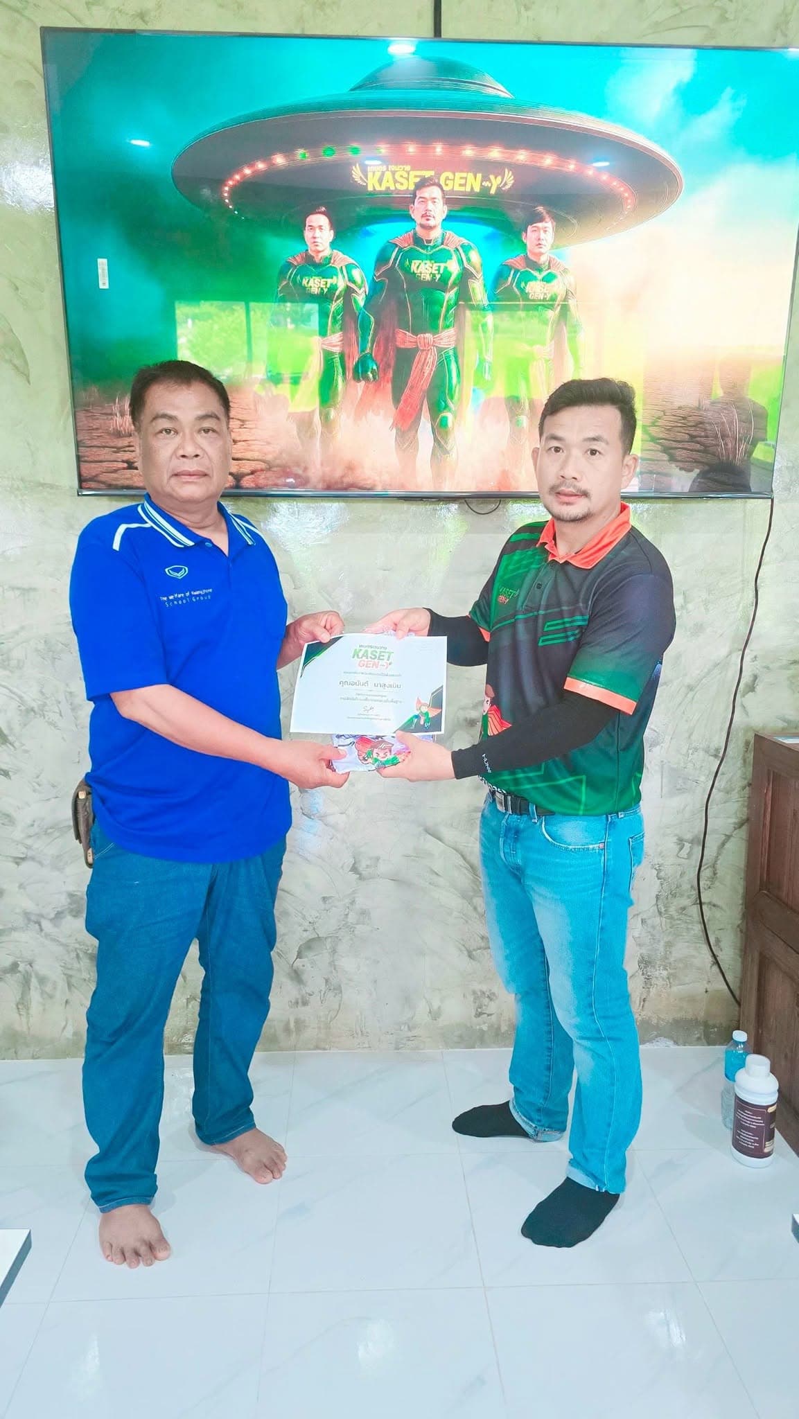 ผู้เข้าอบรมเสื้อสีน้ำเงินรับเกียรติบัตรจากครูฝึก