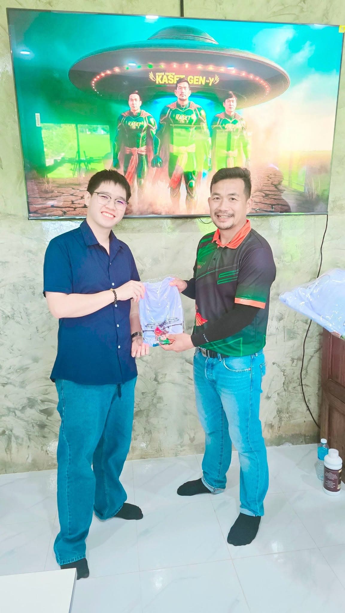ผู้เข้าอบรมเสื้อเชิ้ตสีกรมท่ารับถุงของที่ระลึกจากครูฝึก